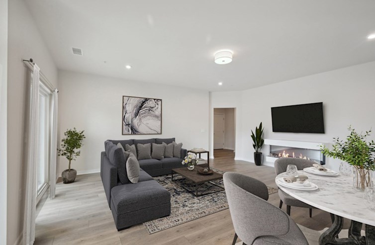 Denmark living room and dining room featuring an electric fireplace, wall mounted tv, laminate floors, a flush mounted ceiling light fixture, three mini flush mounted lights, and access to the foyer