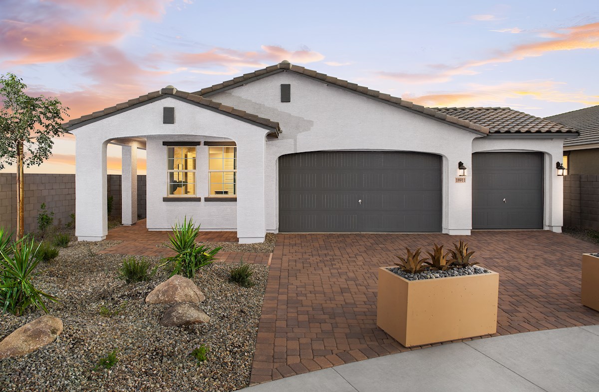 paver driveway with planters and a covered entry