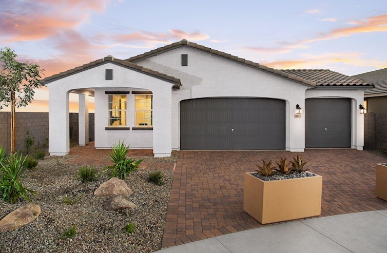 paver driveway with planters and a covered entry