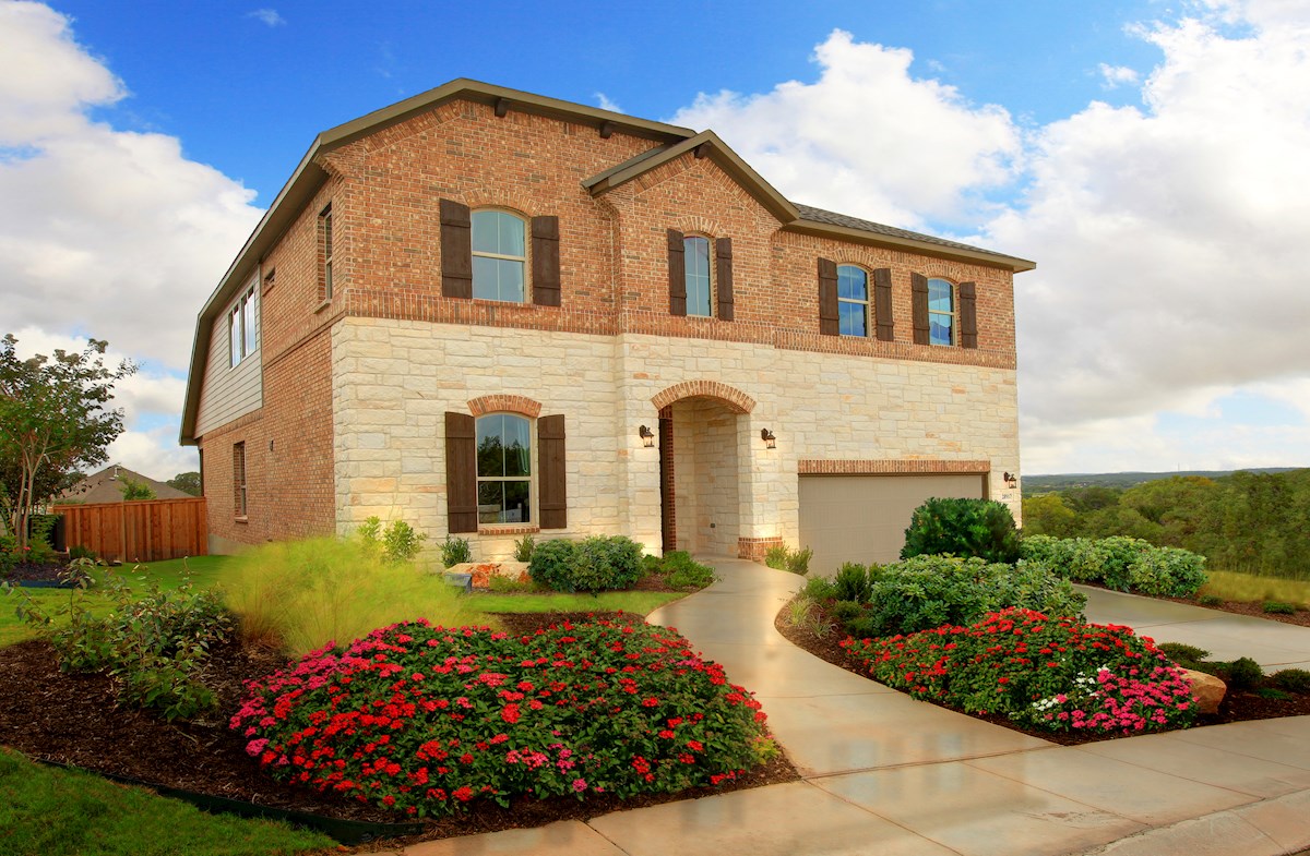 brick and stone exterior with front yard flowers