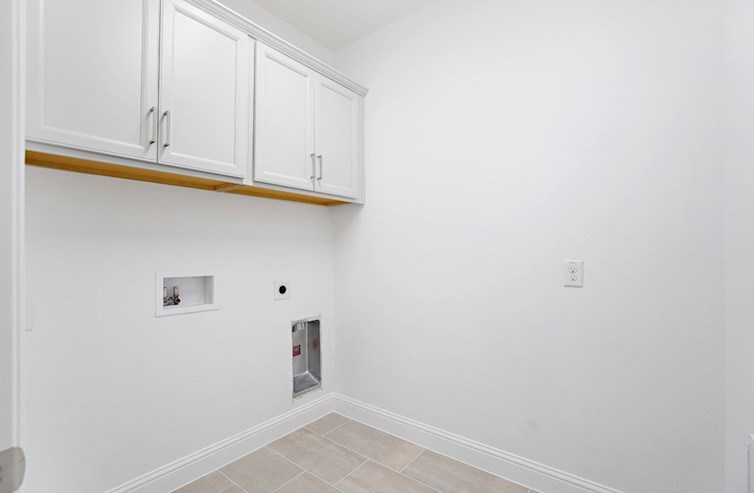 Clifton laundry room with tile floor and white upper cabinets