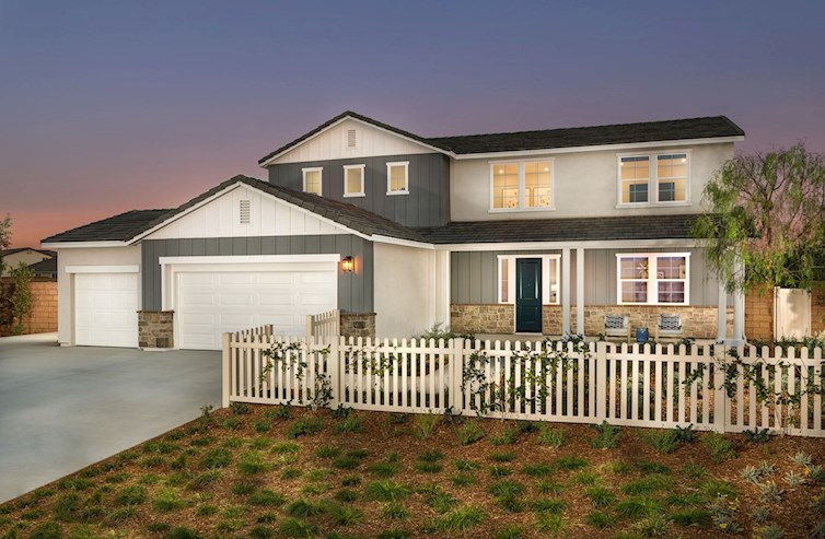 two-story model home with white picket fence