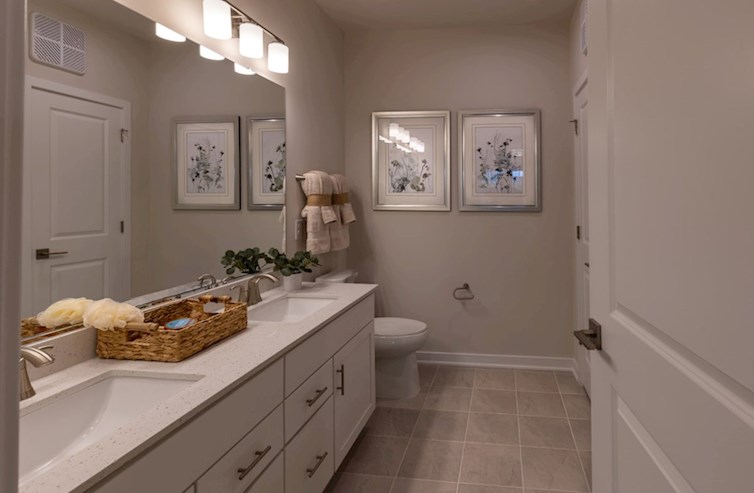 Bradford primary bathroom with dual sinks and white cabinetry