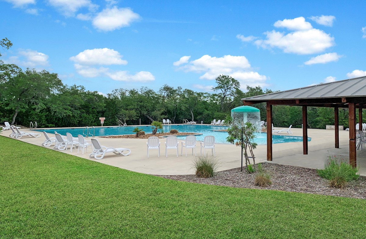 community pool with lounge chairs and splash pad