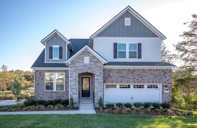 Front exterior of home with stone entry and garage