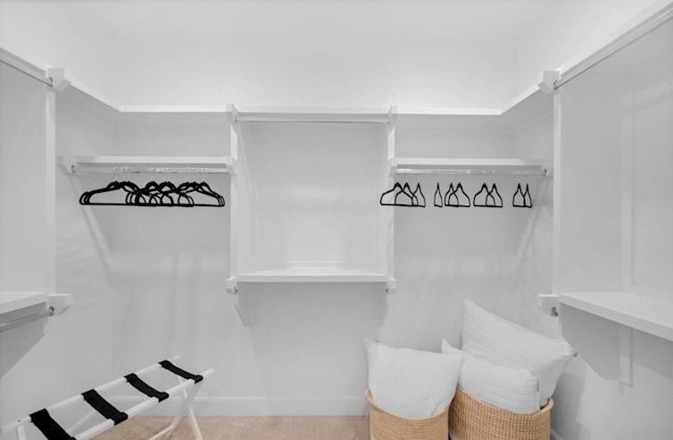 Dorset closet with hangers and basket of pillows 