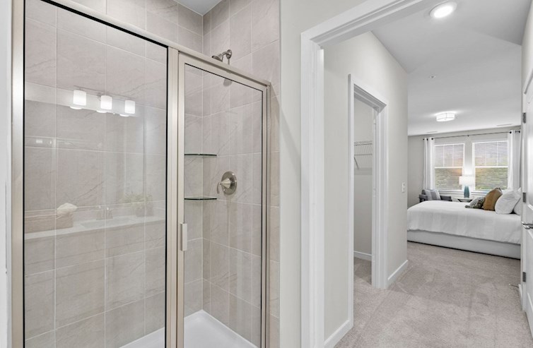 Bradford primary bathroom with large walk-in shower with framed satin nickel enclosure and handset ceramic wall tile