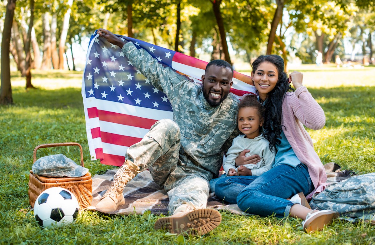 military family holding up American flag
