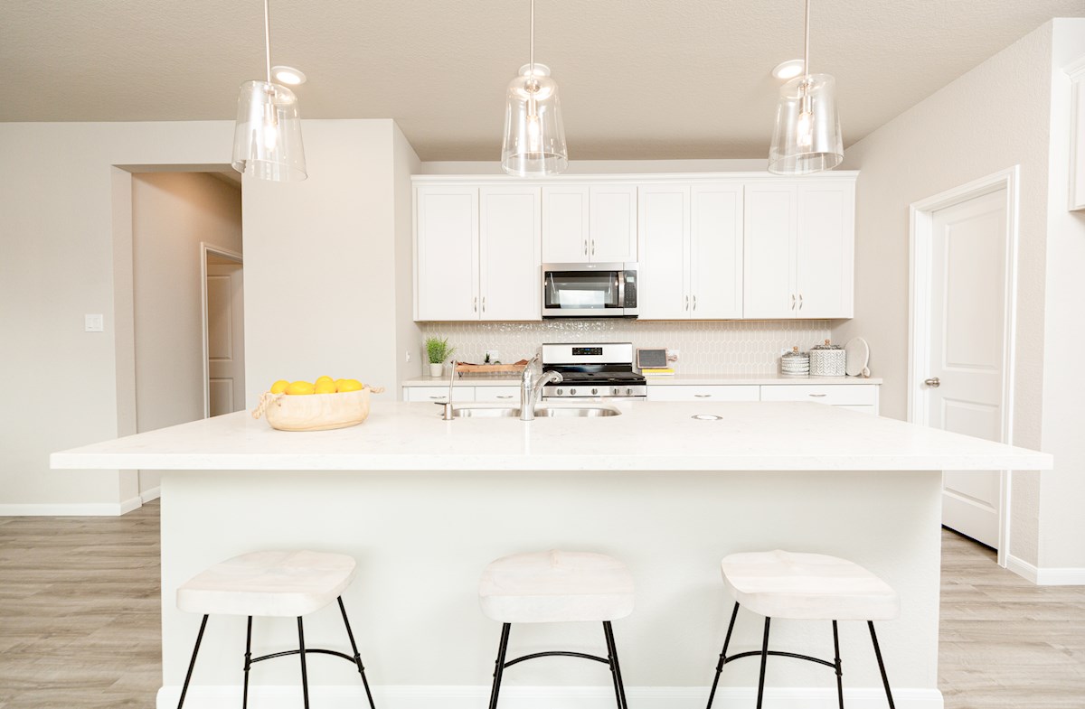 kitchen with white cabinetry & pendant lights