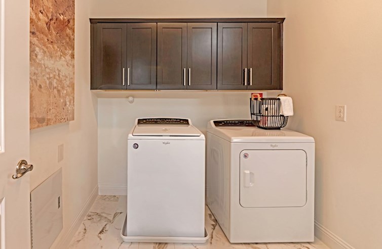 Sherwood laundry room with tile floor and dark upper cabinets