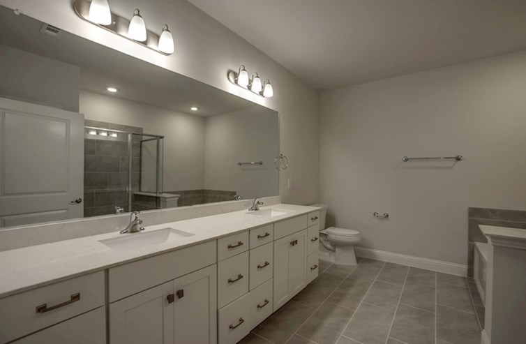 Dorset primary bathroom with two sinks and white cabinets