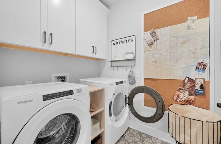 Clifton laundry room with fun tile flooring and upper cabinets for storage