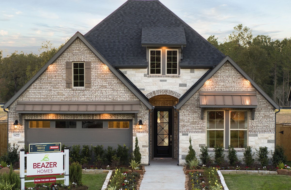 brick & stone exterior with shrubs & grass