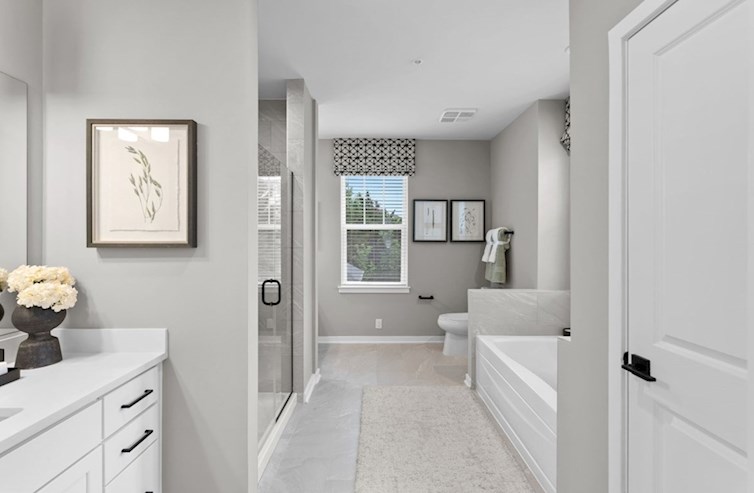 Dogwood primary bathroom with a deep soaking tub and a walk-in shower with a seat and frameless enclosure